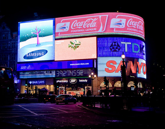 The adverts at Piccadilly Circus lend an eerie glow to the damp road surface.