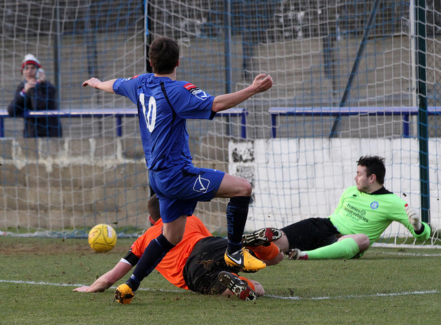 ...or Slot the ball calmly home under presure from the defence.