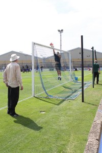 Cain tips a Gavin cross over the bar as the ground staff try to get the goal erected.