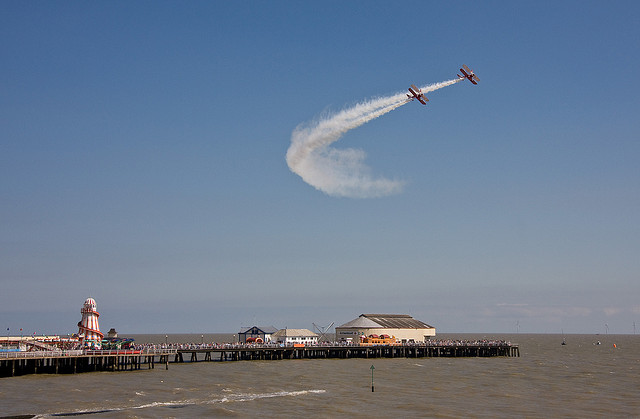 A pair of Stearman biplanes with wing-walkers over Clacton Pier