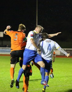 Mark Kirby torture a football as he defends a Wingate corner.