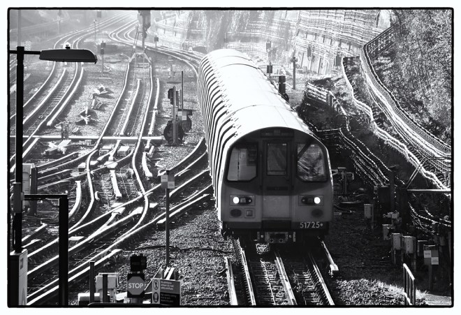 A Northern Line train takes the Mill Hill East branch at Finchley Central on a misty spring morning.